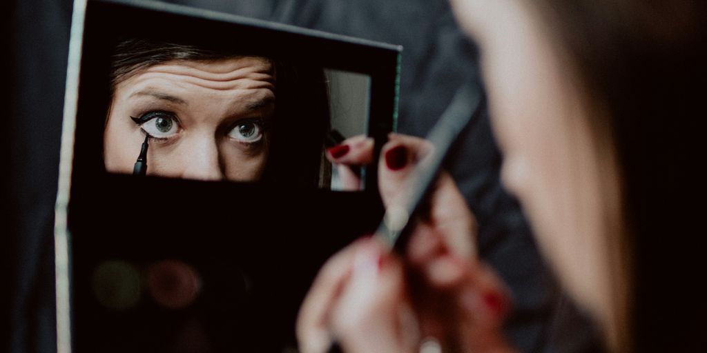 woman holding black framed mirror