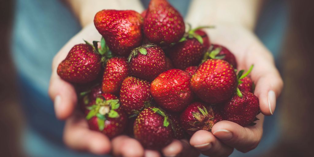 shallow focus photography of strawberries on person's palm