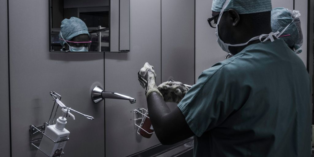 man wearing surgical suit near mirror