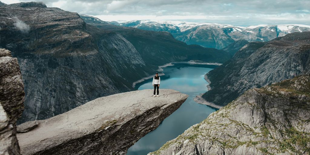 a person standing on a cliff above a body of water