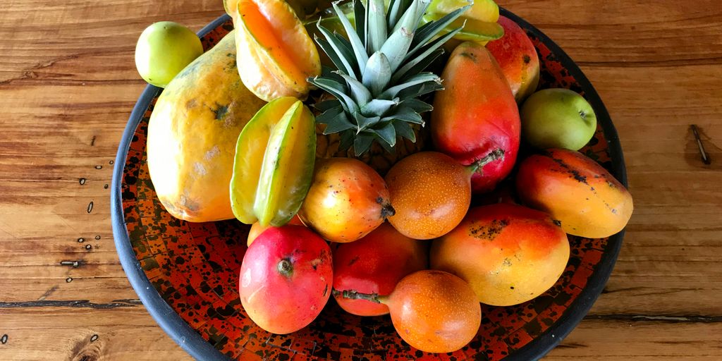 a bowl filled with fruit on top of a wooden table